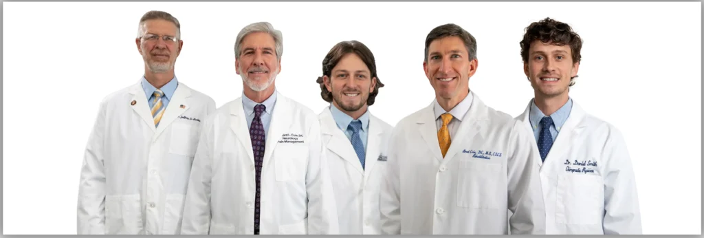 Group photo of five chiropractors from Cole Pain Therapy Group in white lab coats, standing together against a white background.