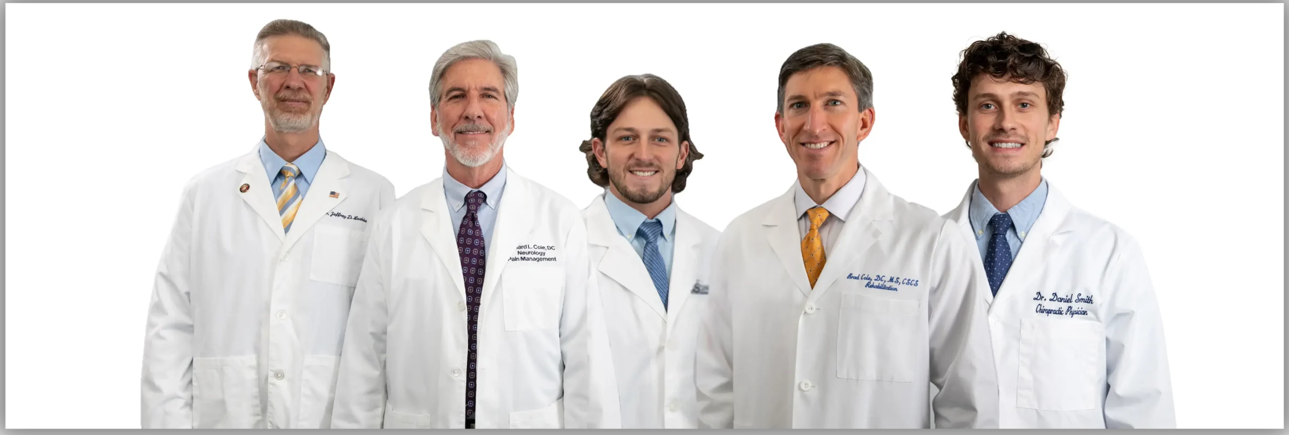 Group photo of five chiropractors from Cole Pain Therapy Group in white lab coats, standing together against a white background.