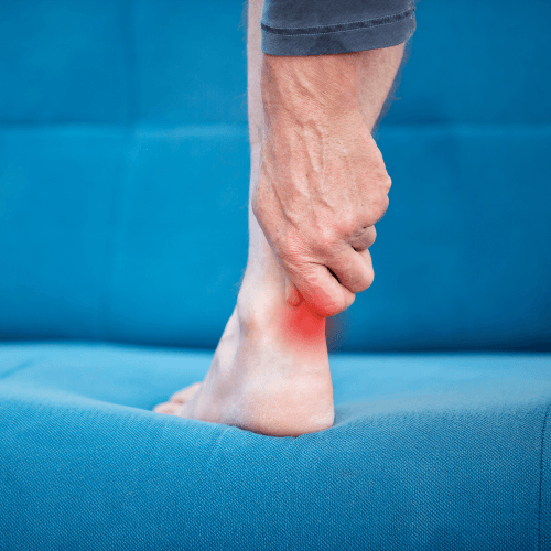 Person holding the back of the heel with highlighted pain indicating Achilles tendinopathy.
