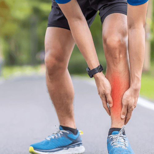 Runner holding the lower leg with highlighted pain along the shin indicating medial tibial stress syndrome.
