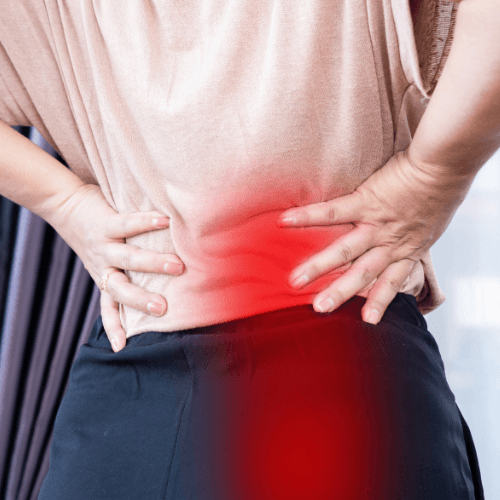 Person holding their lower back with highlighted pain radiating into the buttock, illustrating sciatica symptoms.