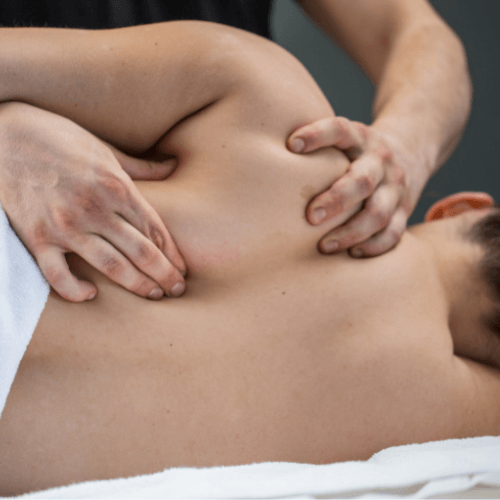 Clinician performing myofascial release therapy on a patient's upper back and shoulder to address soft tissue tension.