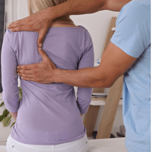 Chiropractor examining a patient's upper and mid-back before performing a first chiropractic adjustment.