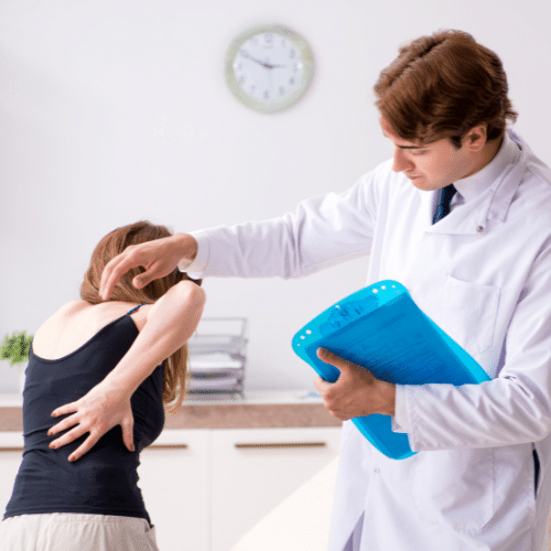 Chiropractor evaluating a patient with back pain during a follow-up chiropractic visit.